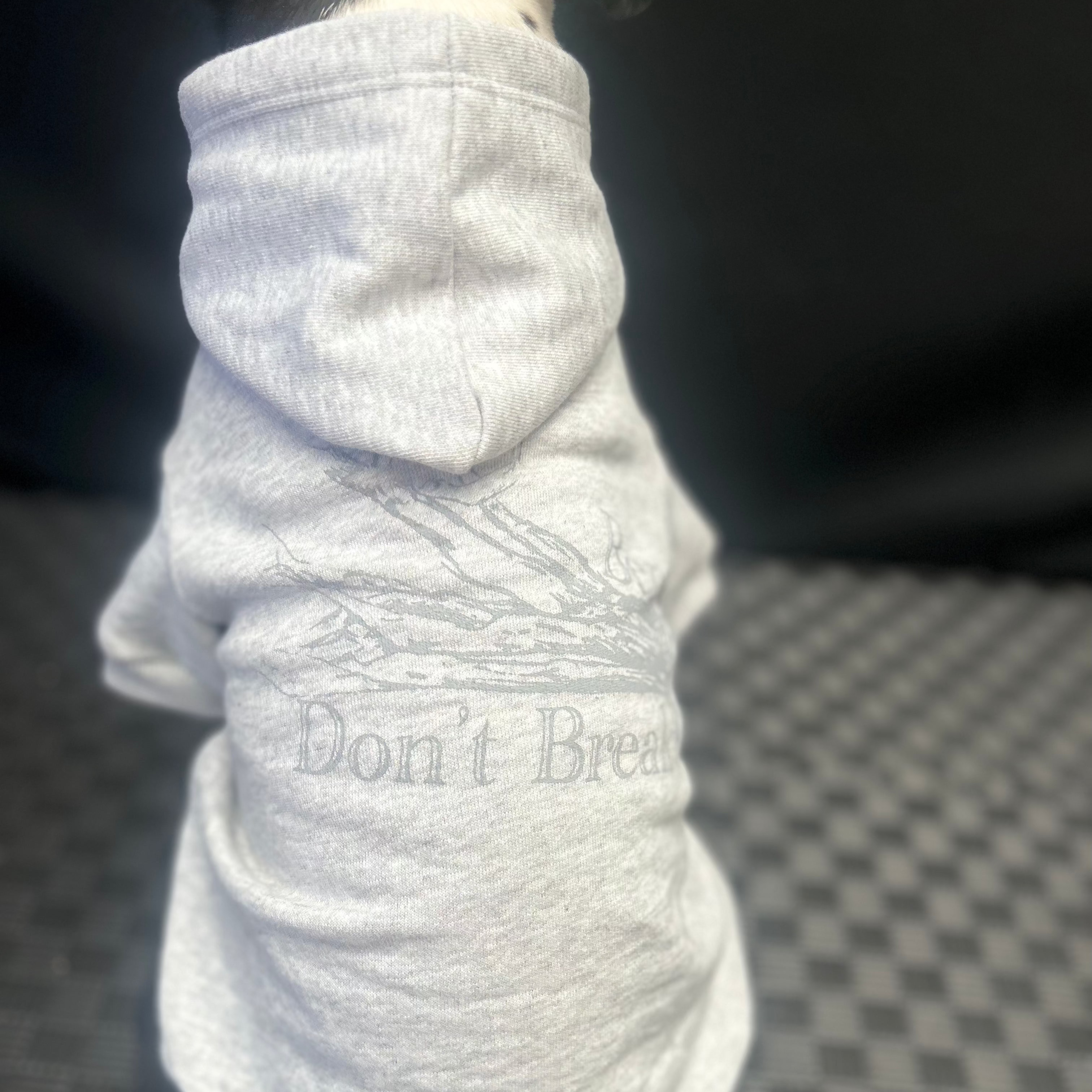 Back view of Fur-You’s ‘Bend Don’t Break’ hoodie in grey print on grey marle, worn by Bonnie. The subtle, tonal design blends beautifully, symbolizing resilience and strength
