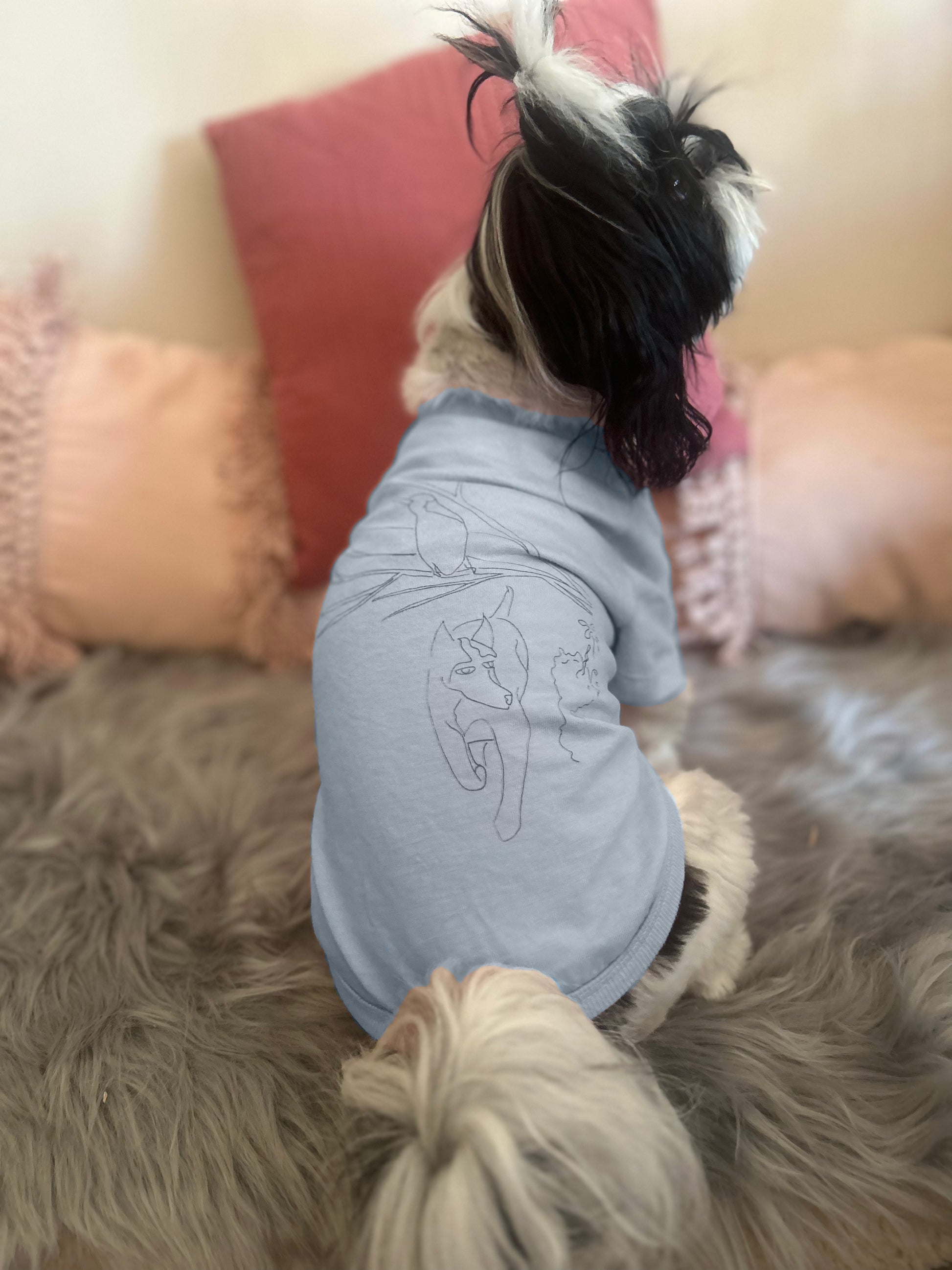 Clara, a small Shih Tzu, wears an XS dusty blue tee featuring Fur-You’s ‘Charlie and the Bird’ print in blue. The back view highlights the design’s placement and relaxed fit.