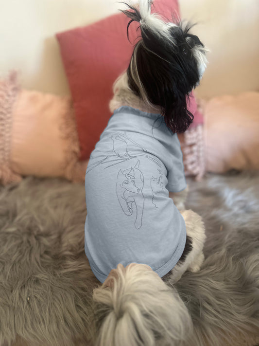 Clara, a small Shih Tzu, wears an XS dusty blue tee featuring Fur-You’s ‘Charlie and the Bird’ print in blue. The back view highlights the design’s placement and relaxed fit.