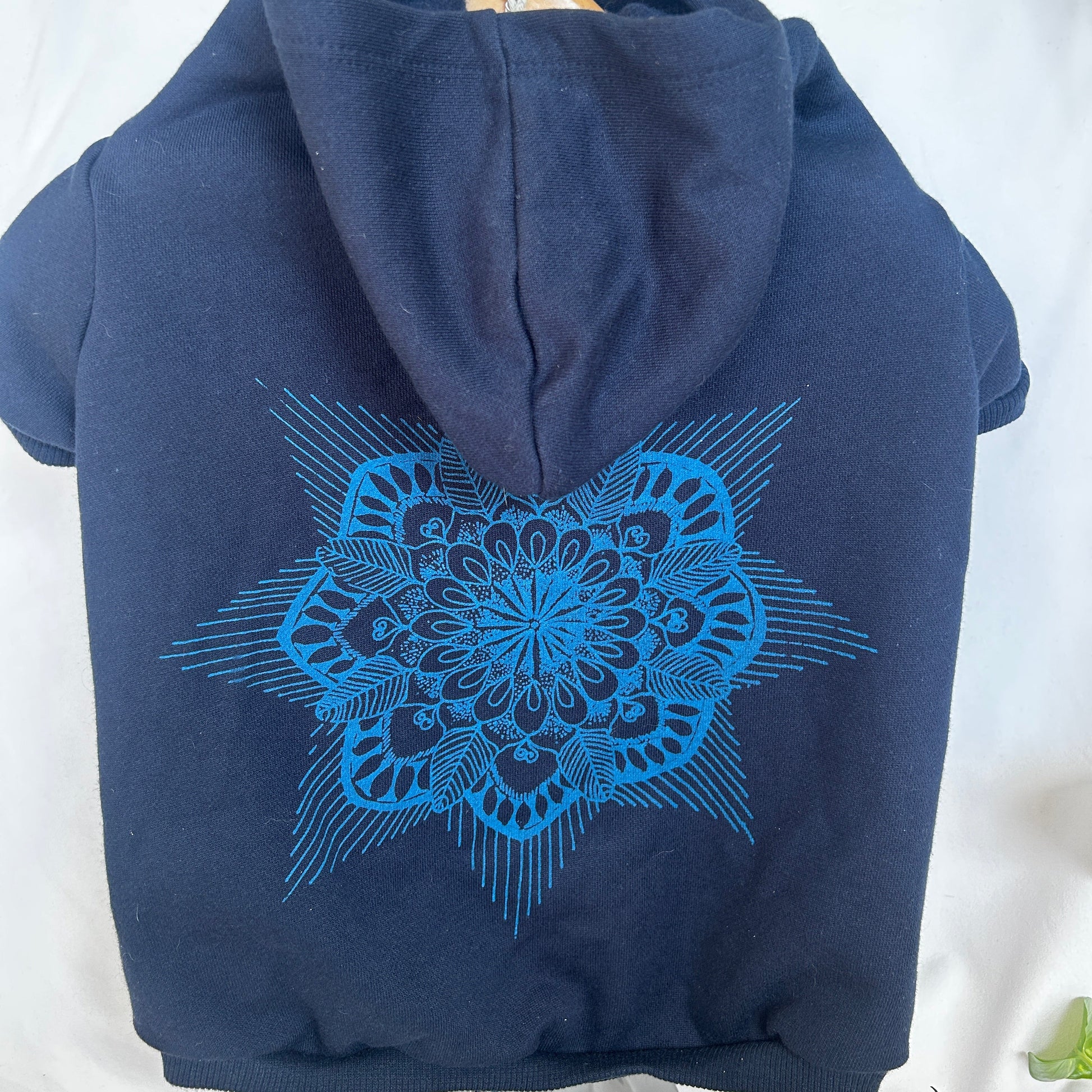 Close-up detail of hand-printed mandala design on blue dog hoodie