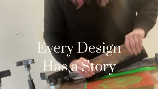 Mel's hands screen printing the Mandala design in glow green ink, lifting squeegee to reveal hand-printed dog clothing art