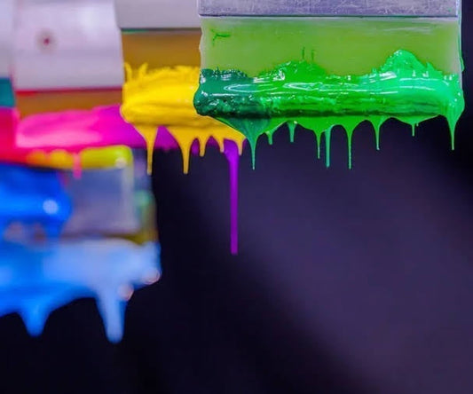 Array of screen printing squeegees showcasing diverse ink colors used in the process