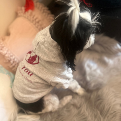 Clara lounges among plush cushions, wrapped in the soft embrace of Fur-You’s Logo Hoodie in grey marle. She gazes curiously out of frame, embodying the brand’s ethos of comfort, sustainability, and mindful living